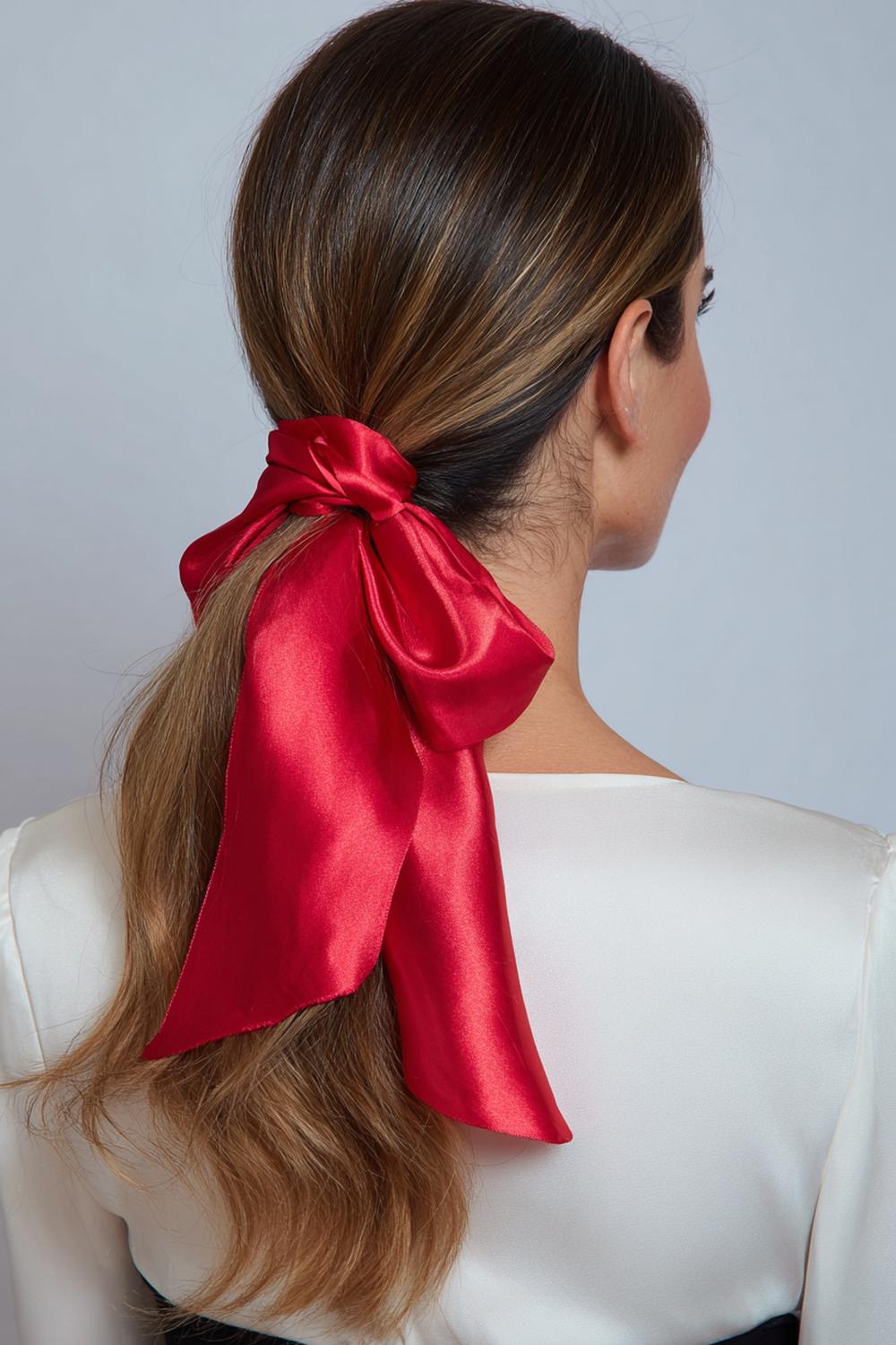 14. Glamour haarlook 2026: sleek lage knot met middenscheiding en satijnen sjaal