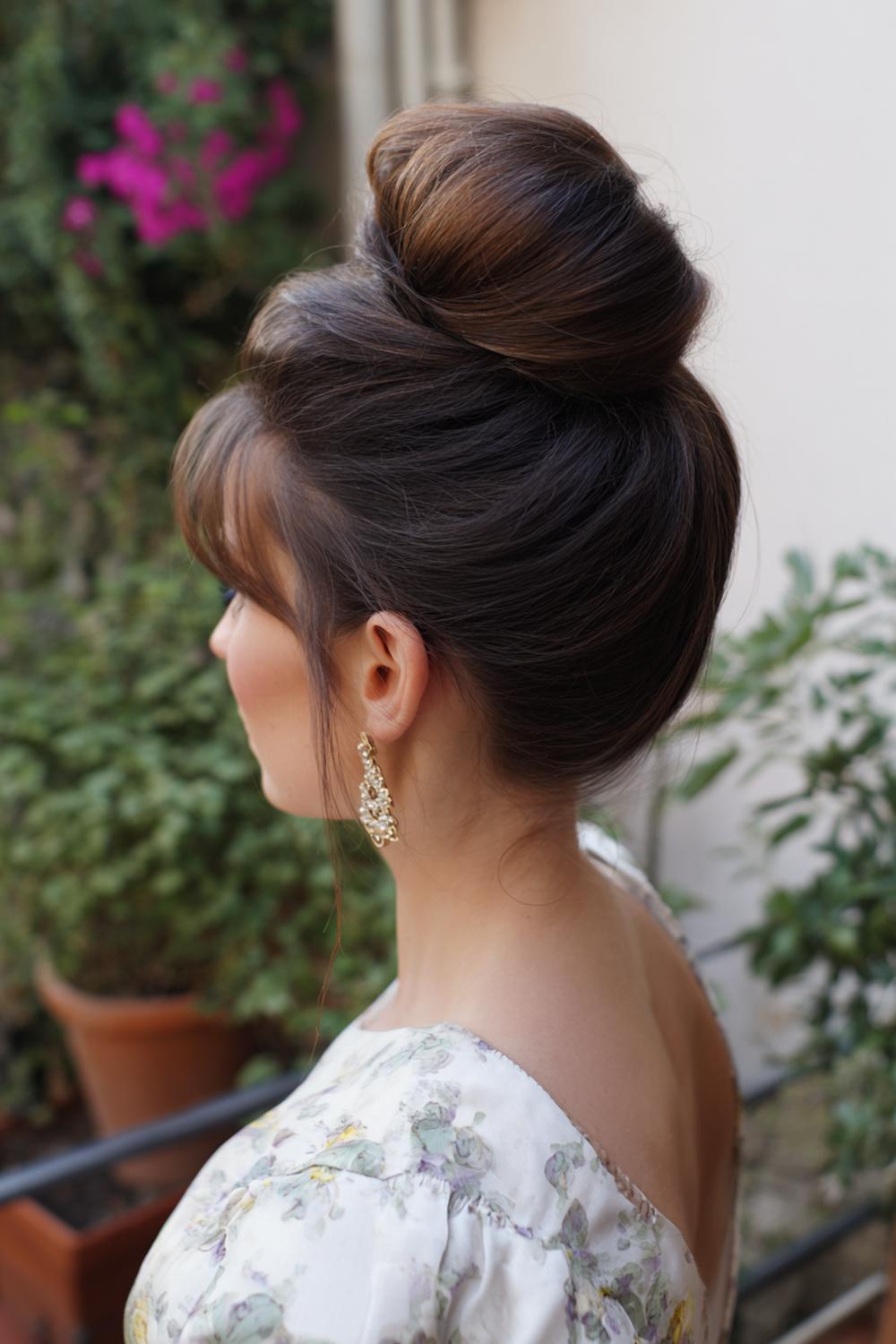 4. Haar updo met hoge, sculpturale knot en strak gelde contouren