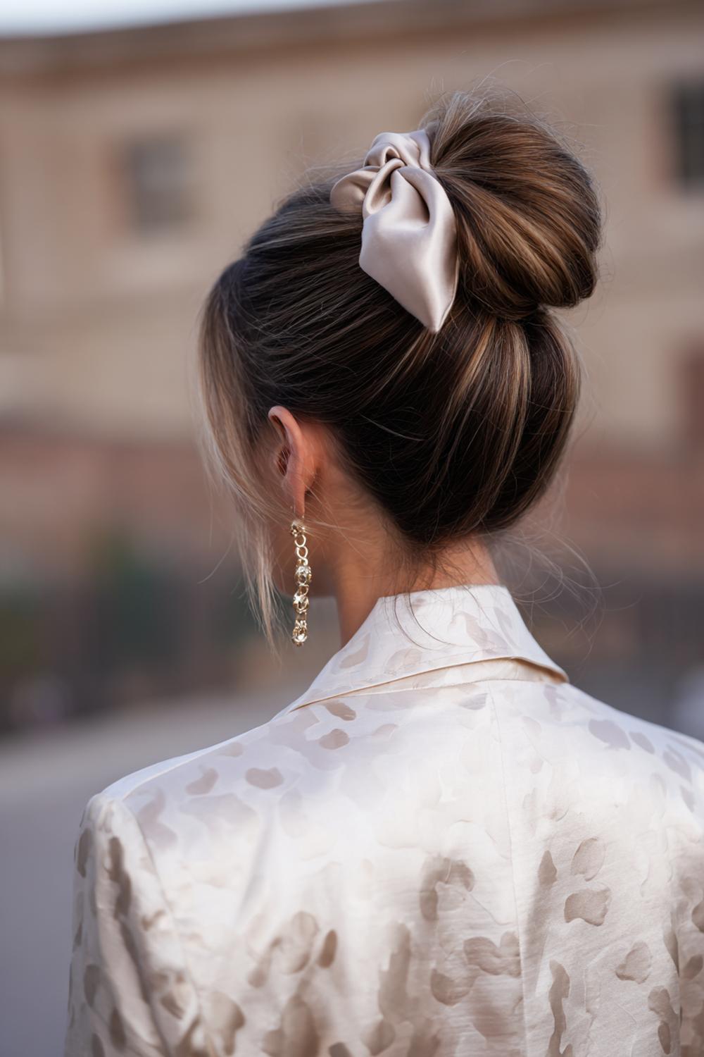 8. Haar updo met lage knot en satijnen strik in nude tinten