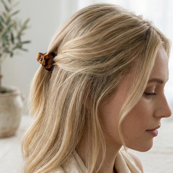 Blond halflang haar half opgestoken met bruine haarclip