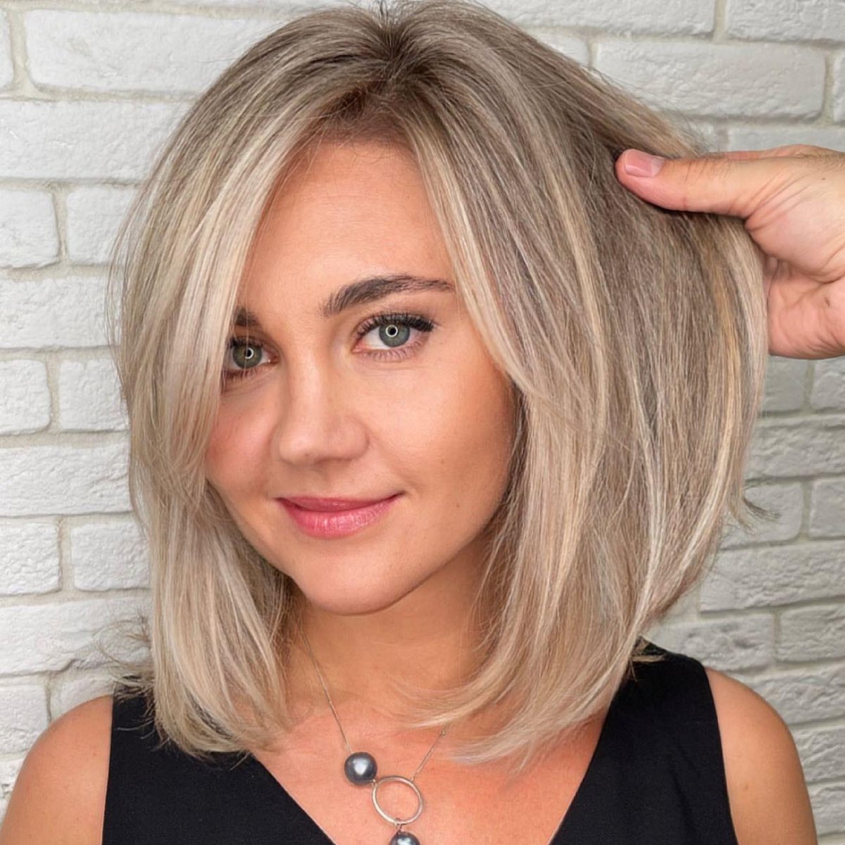 Halflang blond kapsel met zijscheiding en zachte volume