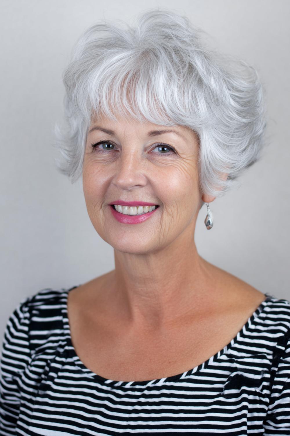 11. Kapsel met pony voor 50 plus: zilvergrijze pixie-bob met lange pony en lift aan de kruin