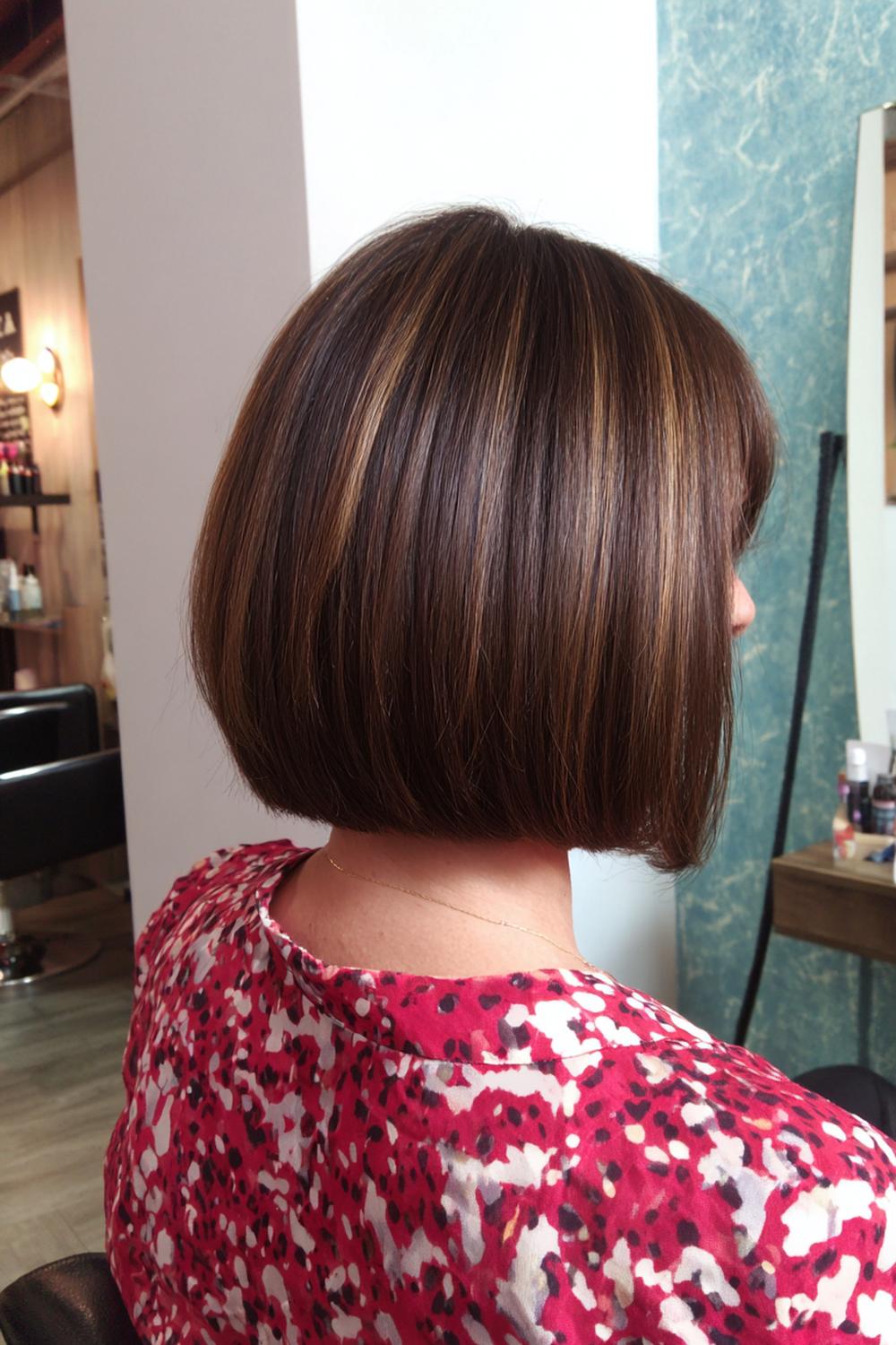 18. Nieuwe Haarstijlen 2026: Krullende bob met afgeronde vorm en glansaccent