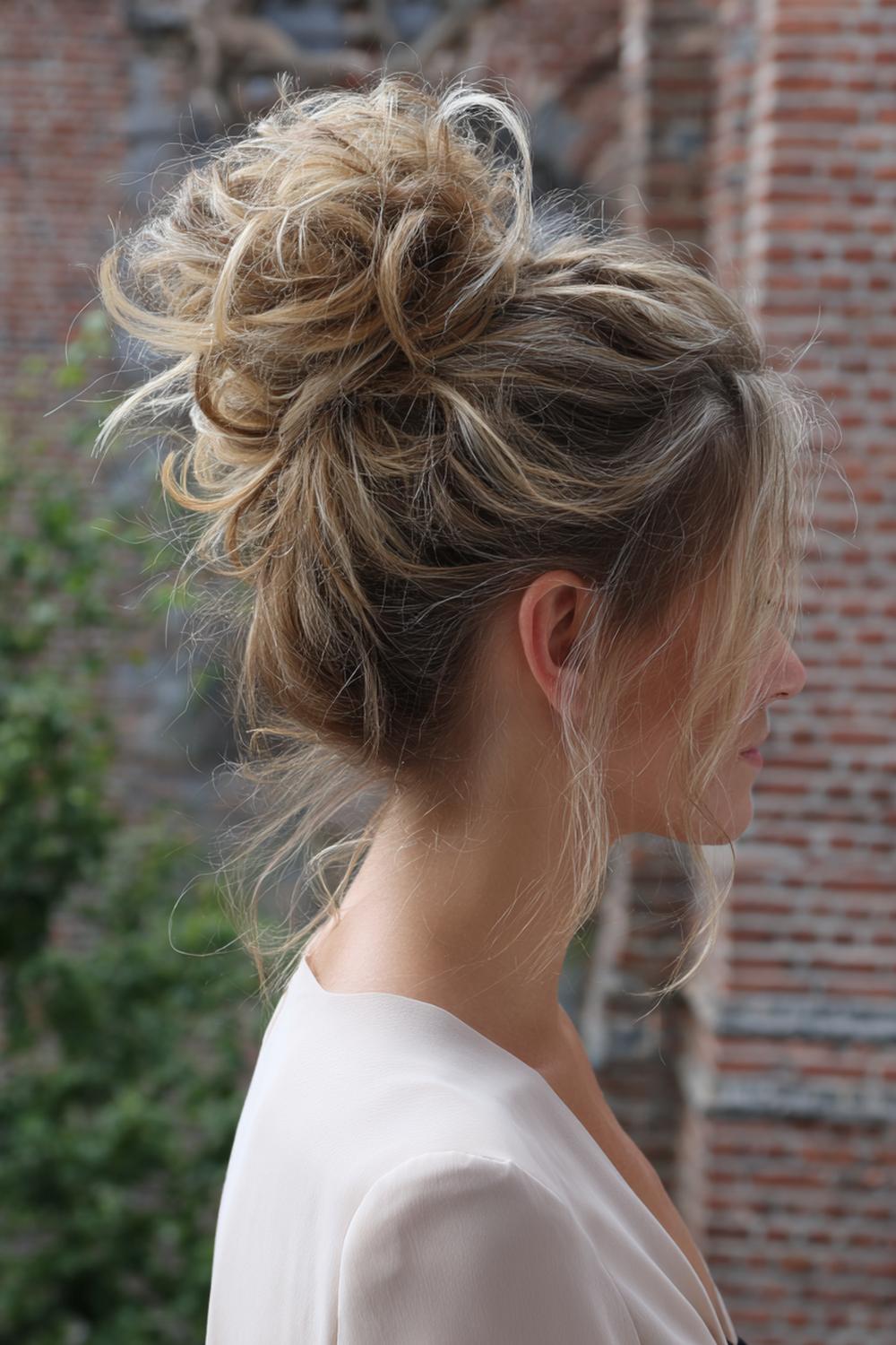 26. Haar: hoog opgestoken messy bun met zachte plukjes en volume