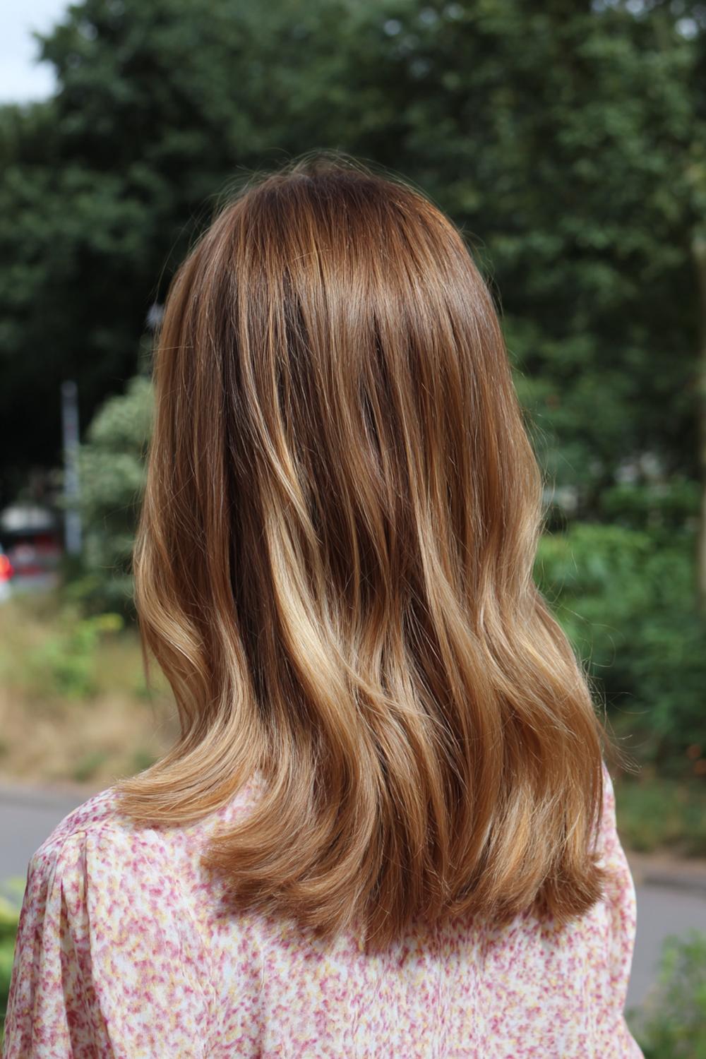 4. Haar: koperkleurige balayage met zonlichtpunten en zachte golf
