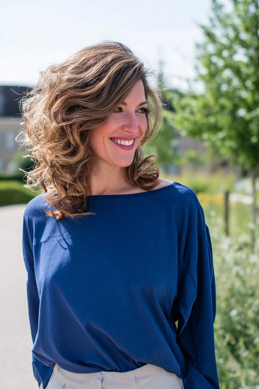 21. Verjongende kapsels voor vrouwen: schouderlange krullen met gedefinieerde scheiding en luchtig volume